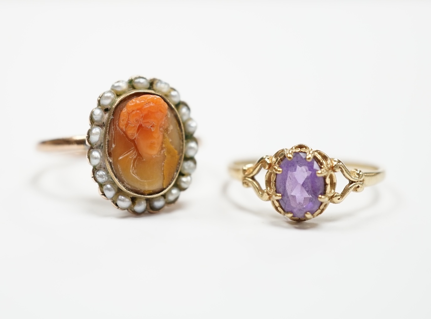 A modern 9ct gold and single stone amethyst set ring and a yellow metal, carved coral and split pearl set ring.